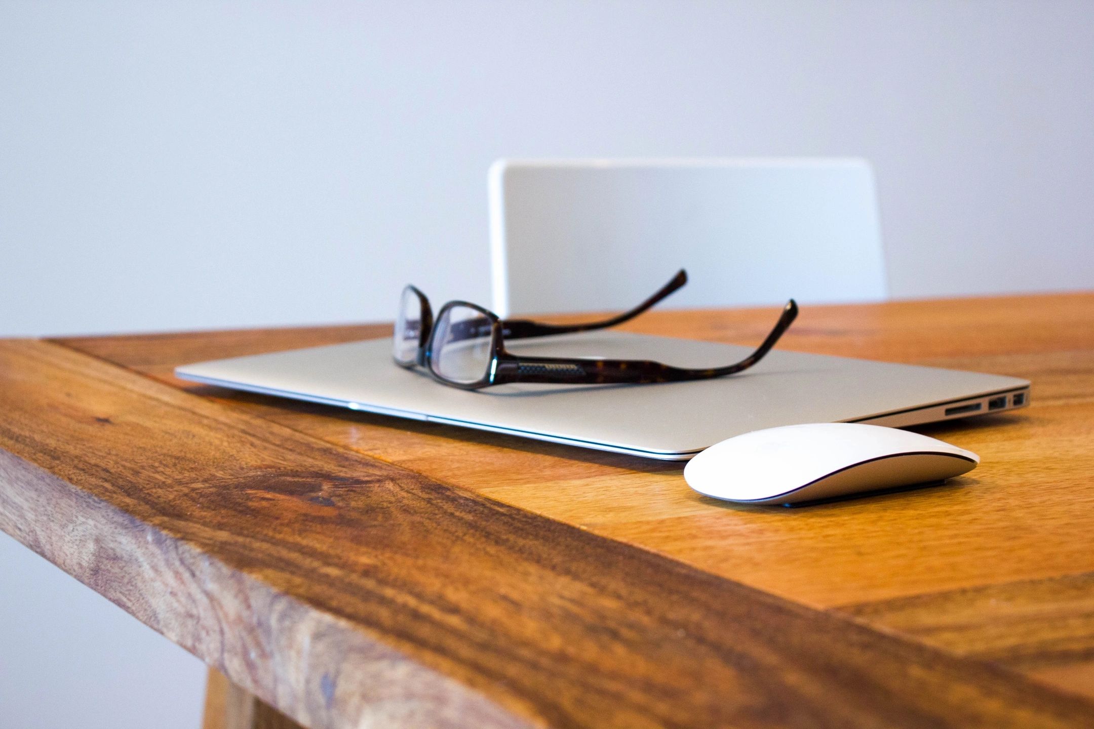 glasses on a desk with a business macbook